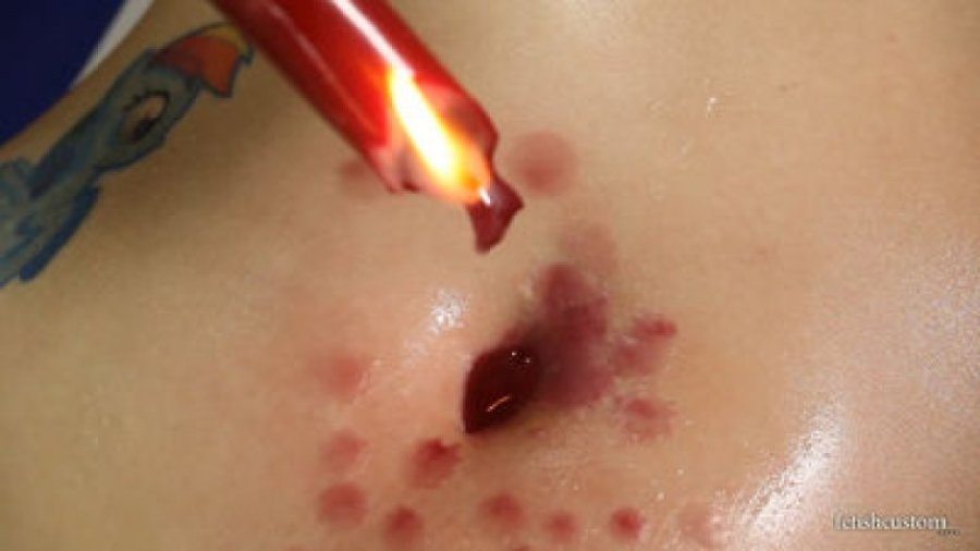 Amber drips candle wax into her bellybutton